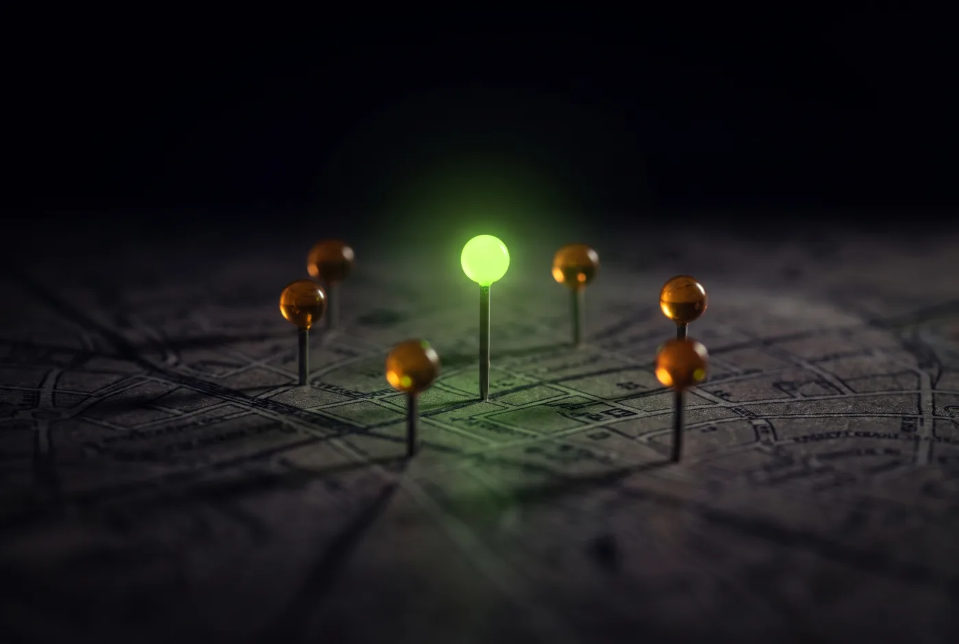 Glowing map pins standing on a dark city street map